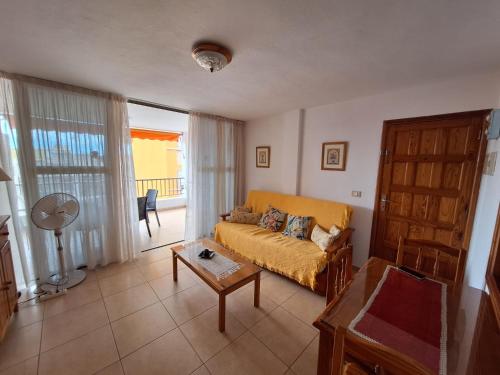 una sala de estar con un sofá y una mesa en Gloria Apartament, en Puerto Naos