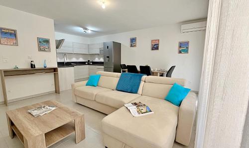 a living room with a couch and a table at Charmant appart rénové centre plages à 5 minutes in Théoule-sur-Mer