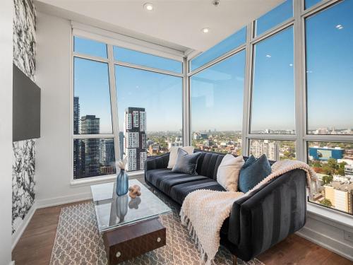 a living room with a couch and large windows at Sofitel Suites - Toronto's Entertainment District in Toronto