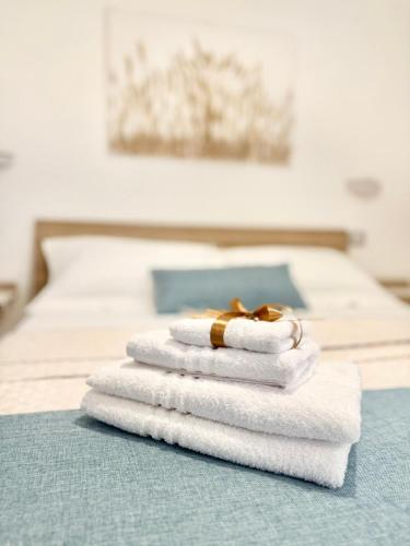 ein Stapel Handtücher mit einem Ring obendrauf in der Unterkunft Dama House in Porto Torres