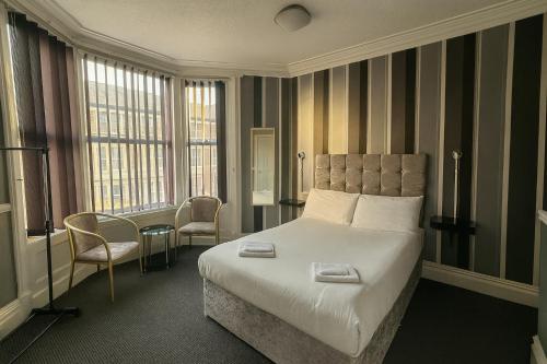 a hotel room with a bed and two chairs at Rest and Welcome B&B, Blackpool in Blackpool