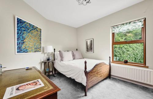 ein weißes Schlafzimmer mit einem Bett und einem Fenster in der Unterkunft River Cottage - Causeway Coast - Coleraine in Fish Loughan