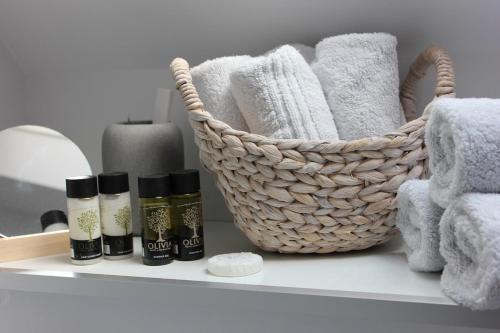 a bathroom shelf with towels and a basket on it at April Cottage in Lymington