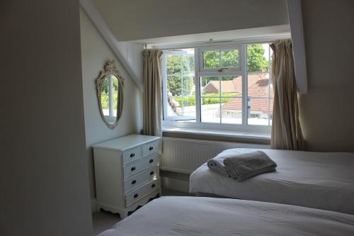 a bedroom with two beds and a window at April Cottage in Lymington