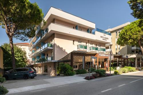 a building with a car parked in front of it at Olimpia Hotel & Aparthotel in Bibione