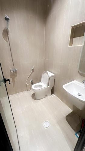 a bathroom with a toilet and a sink at Modern apartment with elegant design in Dhahran