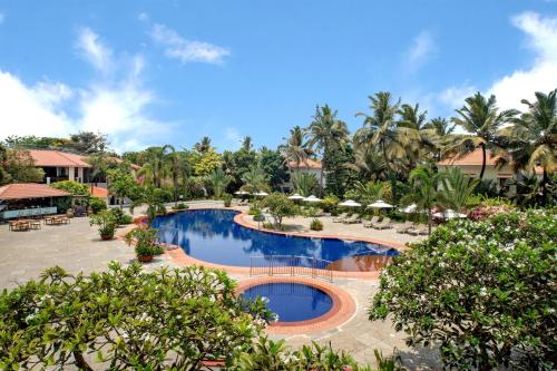 a pool at a resort with palm trees at Radisson Blu Resort, Goa in Cavelossim