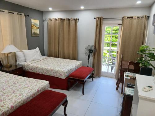 a hotel room with two beds and a window at Comfort Zone at The Ridge E17 in Ocho Rios