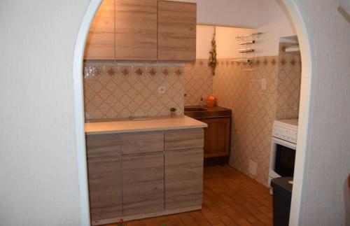 a kitchen with an archway leading into a small kitchen at Le Mas Des Glycines in Les Vignères