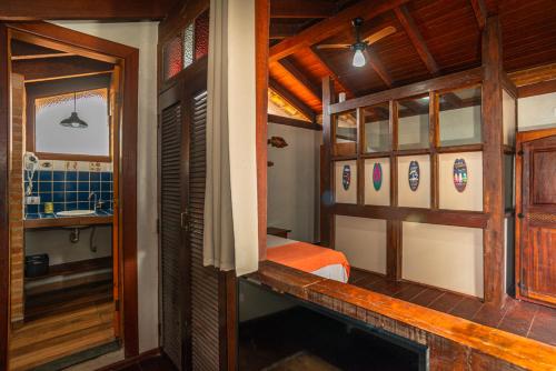 a small room with a bed and a bathroom at Villa do Portinho - Casas em frente à Praia in Ilhabela