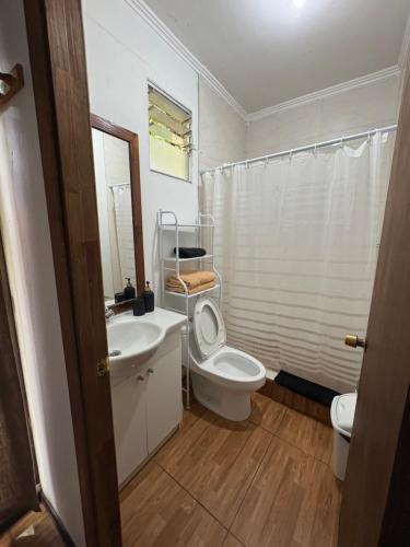 ハンガ・ロアにあるPumakari Rapa Nuiのバスルーム(白いトイレ、洗面台、トイレ付)