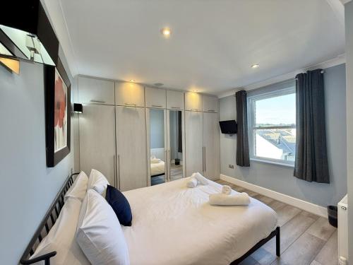 a bedroom with a large white bed and a window at Sunnybeach in Seaton