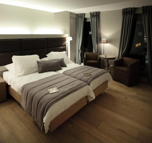a bedroom with a large bed and two chairs at Tuinhotel in Lommel
