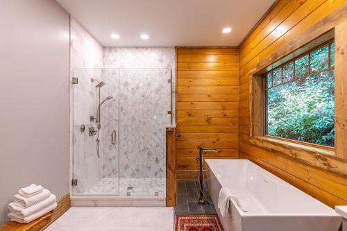 bagno con doccia e vasca bianca di A High Country Retreat a Boone