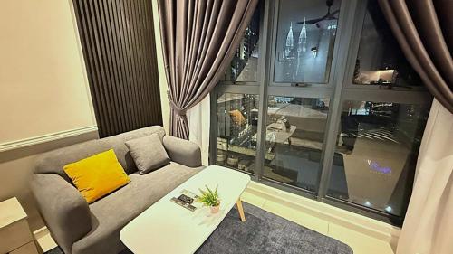 a living room with a couch and a table and a window at Majestic Residence Suites KLCC in Kuala Lumpur