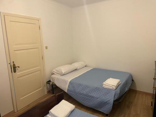 a small bedroom with a bed and a door at Casa na praia 2- Maia in Maia