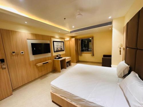 a hotel room with a bed and a television at Hotel The Elite in Jabalpur