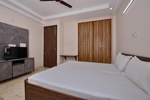 a bedroom with a bed and a flat screen tv at Collection O DLF Cyberhub Gurugram in Gurgaon