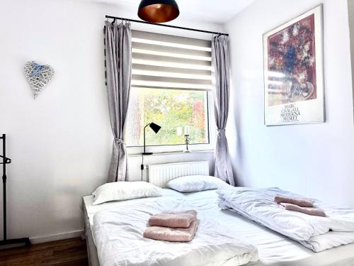 a bedroom with a bed and a window at Familly Apartament 6 in Międzyzdroje