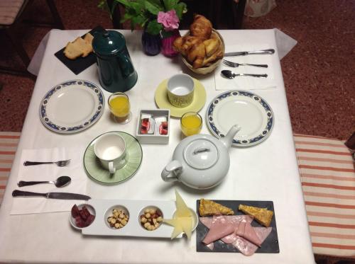 a table with plates and utensils and food on it at Hostal Pirineos in Barbastro