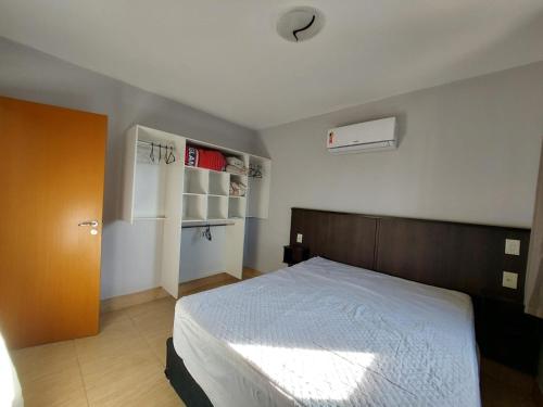 ein Schlafzimmer mit einem großen Bett mit einem hölzernen Kopfteil in der Unterkunft Flat - Fiore Prime Flat Style - 5 pessoas - Apartamento - 5 andar in Caldas Novas