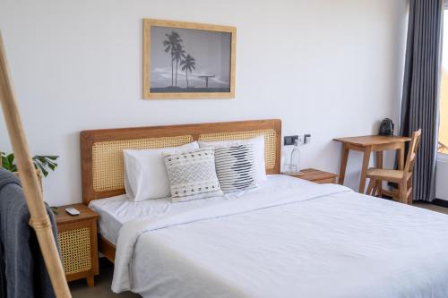 a bedroom with a bed with white sheets and pillows at Sansun Guesthouse in Mirissa