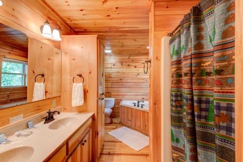 a log cabin bathroom with a sink and a toilet at Chestnut Lodge in Boone