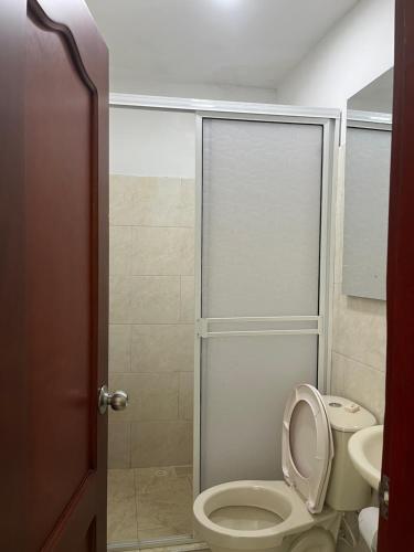 a bathroom with a toilet and a shower at Hotel Maria del Mar planeta Rica in Planeta Rica