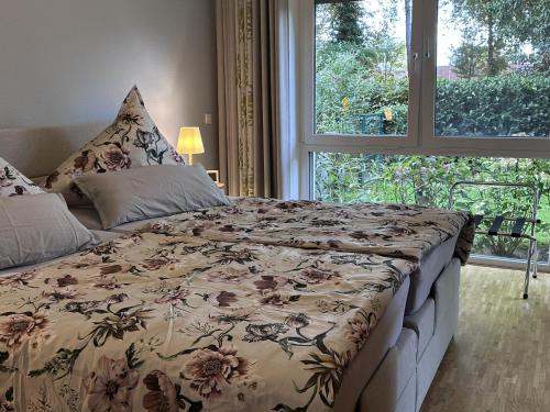 un lit dans une chambre avec une grande fenêtre dans l'établissement Ferienwohnung Seeperle, à Bad Zwischenahn