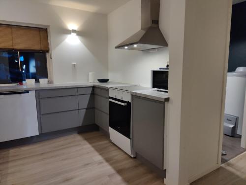 ハーシュタにあるAppartement in Harstadの白いカウンターとコンロ付きオーブンのあるキッチン