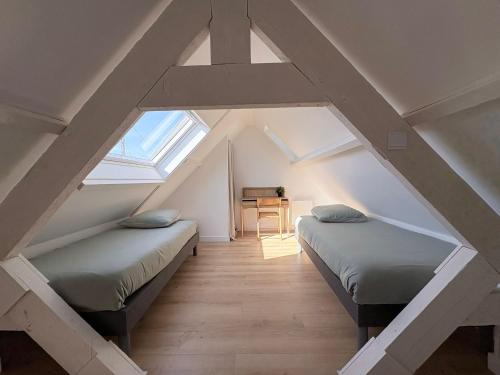 a attic room with two beds and a desk at Location Maison Larmor plage in Larmor-Plage