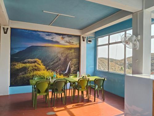 une salle à manger avec un grand tableau mural dans l'établissement DADA TOURIST COTTAGE & Camping site, à Cherrapunji