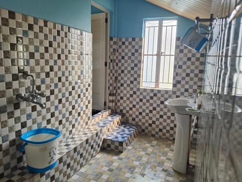 une salle de bain avec un lavabo, des toilettes et une douche dans l'établissement DADA TOURIST COTTAGE & Camping site, à Cherrapunji