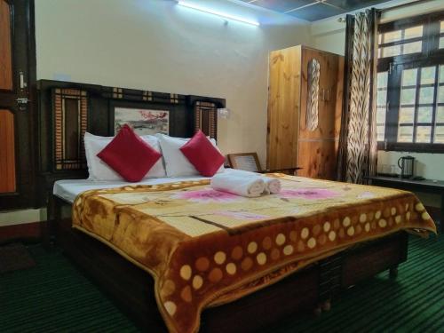 a bedroom with a large bed with red pillows at Hotel classic kuppa sangla in Sāngla