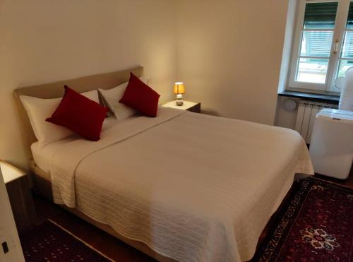 a bedroom with a large white bed with red pillows at Appartamento Piazzetta Portofino (010044-LT-0030) in Portofino