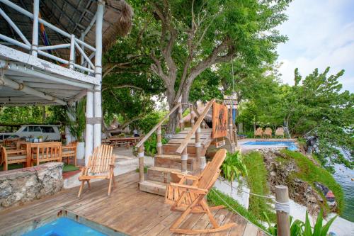 Una terraza con sillas y una escalera junto a una piscina. en Isla Mulata, Islas del Rosario, en Isla Grande