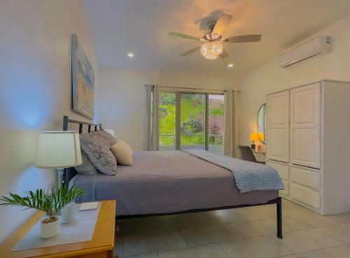 a bedroom with a bed and a ceiling fan at Gorgeous Ocean View Private home, 4 bedrooms with en suite, private plunge pool in Coco