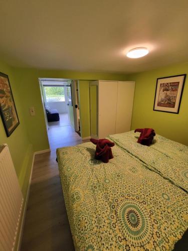 two beds in a room with green walls at L'Echappée verte in Spa