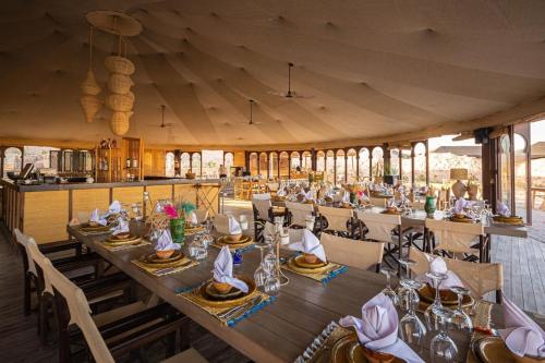 a dining room with a long table and chairs at Les Bedouins Agafay in Oulad Akkou