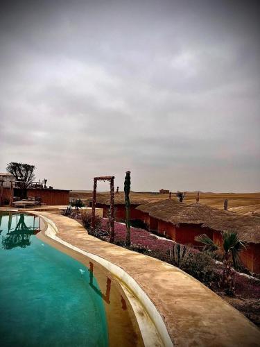 a swimming pool in the middle of a desert at Les Bedouins Agafay in Oulad Akkou
