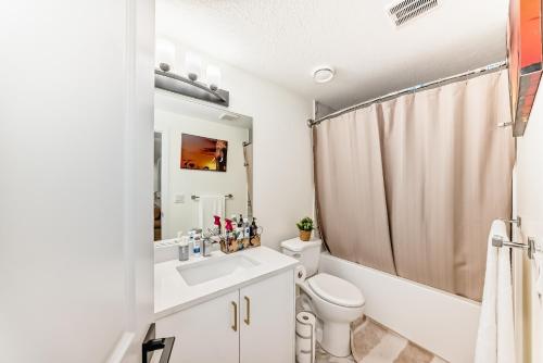 a bathroom with a white toilet and a sink at KimzNest in Edmonton
