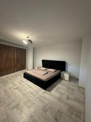 a bedroom with a bed and a wooden floor at Madona Apartment in Craiova