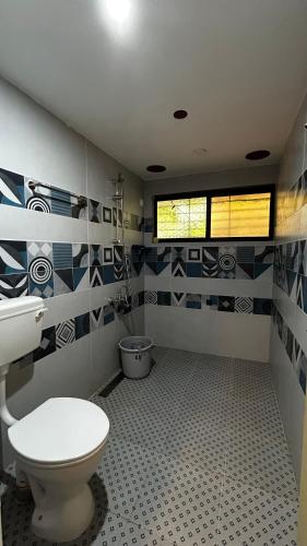 a bathroom with a toilet and a window at Pk Villa in Auroville