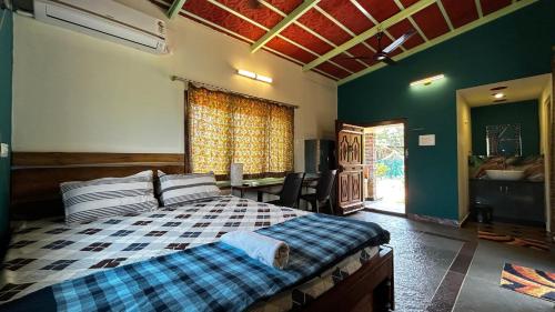 a bedroom with a bed and a table and a window at Pk Villa in Auroville