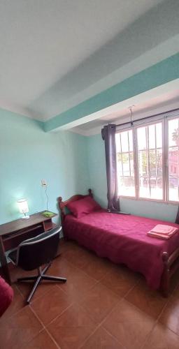 a bedroom with a large red bed and a desk at Alojamiento la posta in Perico