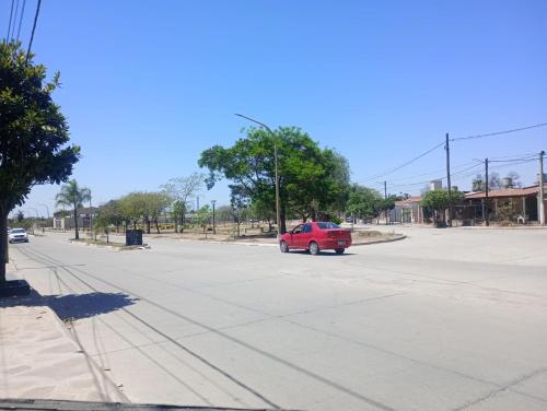 a red car is driving down a street at Alojamiento la posta in Perico