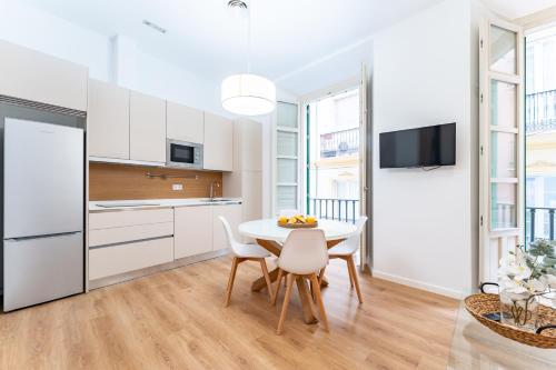 a kitchen and dining room with a table and chairs at Apartamento Centro Histórico I in Málaga