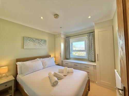 a bedroom with a bed with towels on it at White Cliffs in Seaton