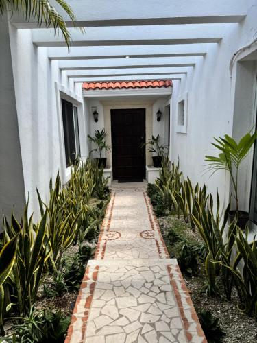 a walkway in front of a building with a door at Casa Mel, Excelente ubicacion, seguridad in Cozumel