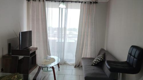 a living room with a couch and a window at Apartamento amoblado de 3 dormitorios con parking incluido in Arica